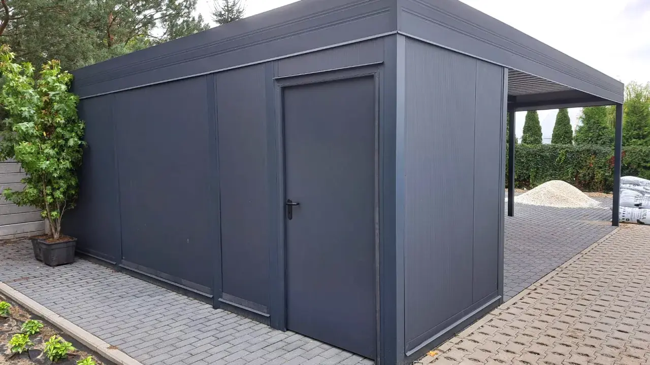 Nowoczesny garaż z wiatą, idealny na działkę bez pozwolenia. Elegancki, ciemnoszary, z praktycznymi drzwiami i zadaszeniem.