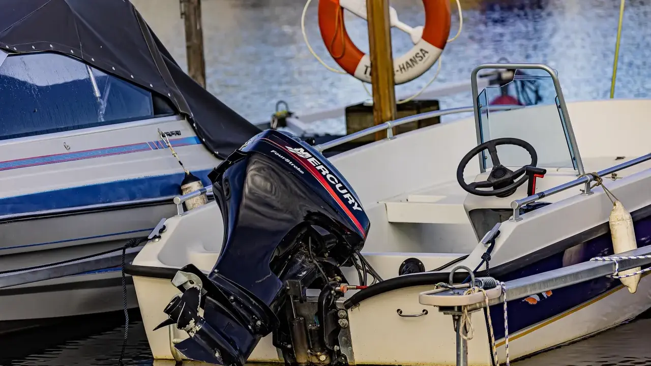 Moteur Mercury hors-bord sur un bateau blanc. Le moteur 2 temps ne démarre pas, il est temps de le réparer.
