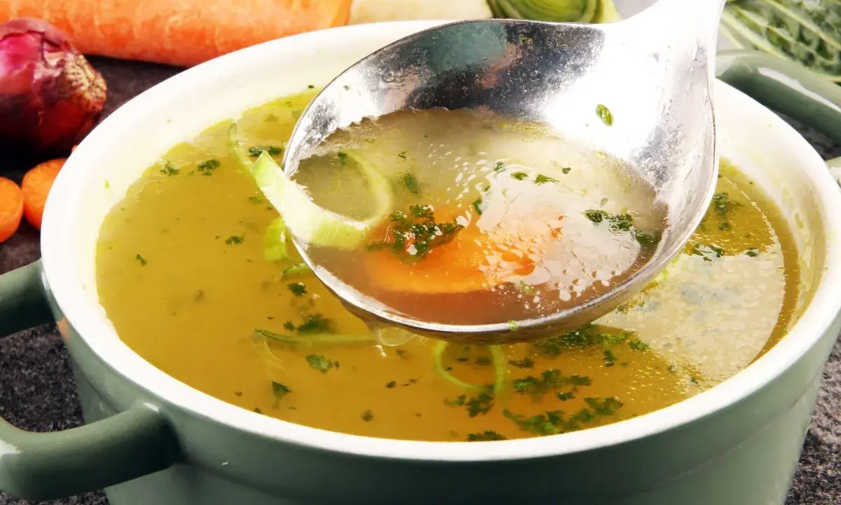 Łyżka nabiera aromatyczny rosół z warzywami. Idealny przepis na to, jak ugotować rosół, który rozgrzeje serce.