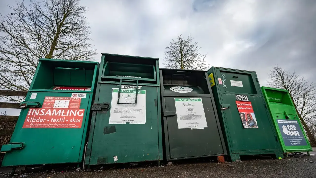 Gröna insamlingscontainrar för kläder, textil och skor. En del av dem visar vad som menas med återvinning genom att samla in begagnade kläder.