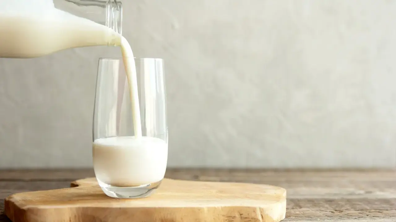 Kefir jest lekkostrawny, co widać na zdjęciu, gdy biały napój jest przelewany z butelki do szklanki.