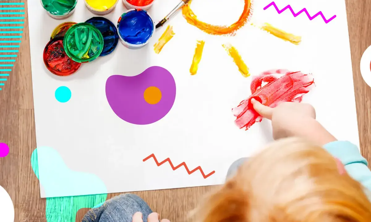 Bambino dipinge un sole con le dita, circondato da vasetti di colori. Un esempio di giochi popolari per bambini che stimolano la creatività.