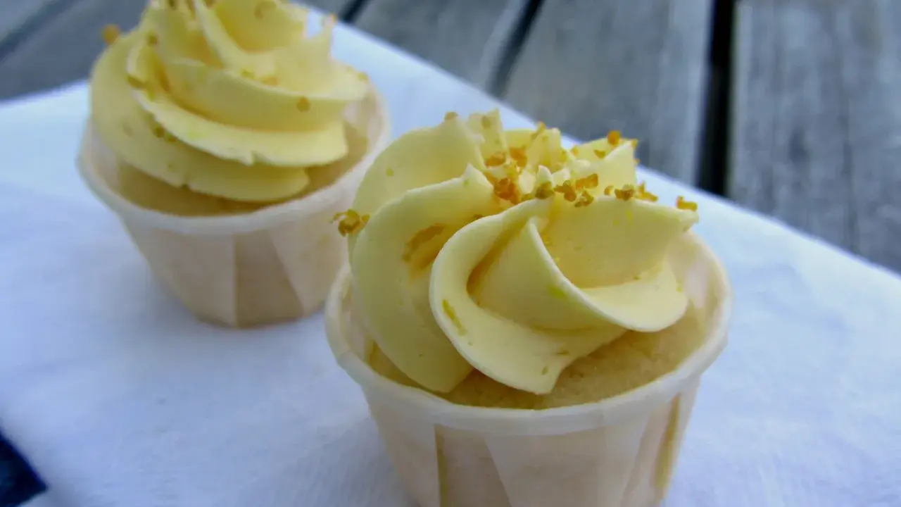 Två läckra citron cupcakes med gul frosting och strössel. Perfekt för en fika.