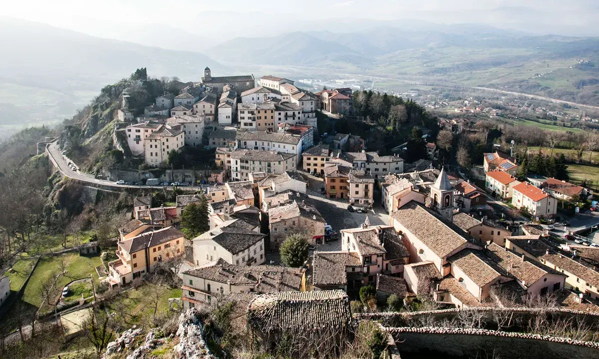 Panoramica di Pennabilli, cosa vedere: borgo medievale arroccato su una collina, con case in pietra, tetti in cotto e una chiesa con campanile.