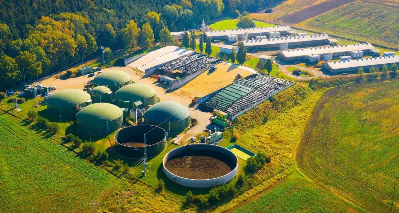 Planta de biogás con biodigestores y granjas. Las desventajas de la biomasa incluyen el uso de grandes extensiones de tierra y la necesidad de infraestructura.