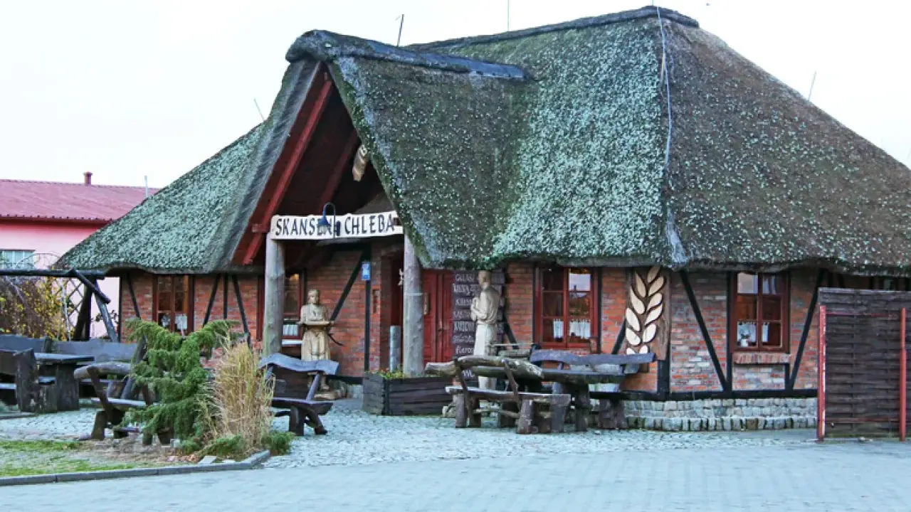 Skansen chleba z charakterystycznym, strzechą krytym dachem. Drewniane ławy i stoły zapraszają do odpoczynku.
