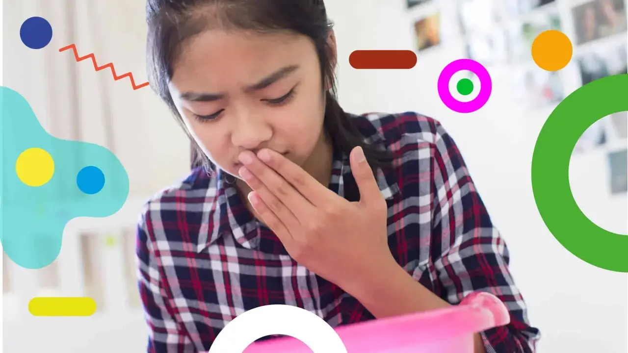 Bambina con nausea, forse per farmaci, copre la bocca con la mano, pronta a vomitare in un contenitore rosa.