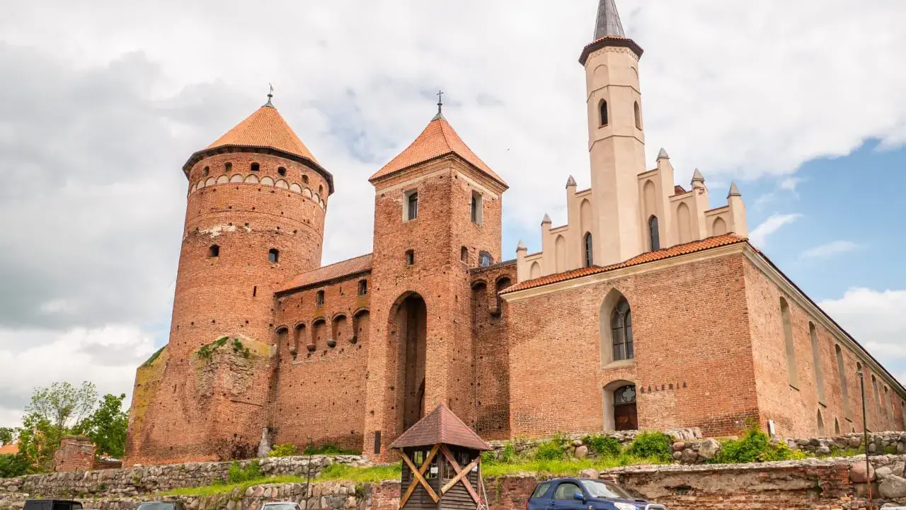 Gietrzwałd-zamek, imponująca budowla z cegły z okrągłą wieżą i strzelistą wieżyczką, zaprasza do zwiedzania.