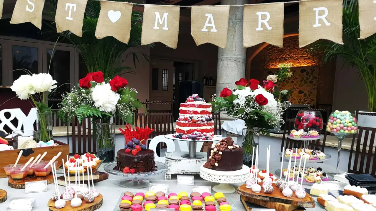 Una mesa de dulces sencillas para una celebración, con pasteles, macarons y cake pops.