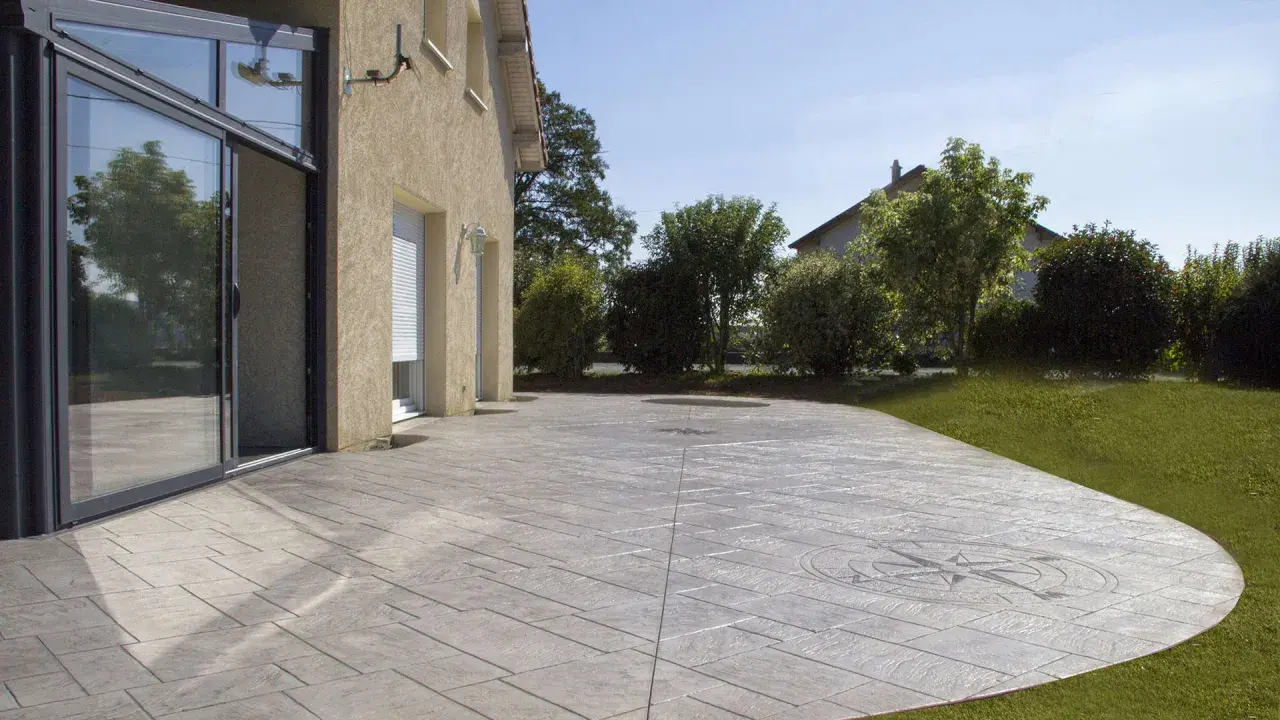 Terraza de hormigón impreso con diseño de brújula, mostrando cómo se hace el hormigón impreso para un acabado elegante y duradero.