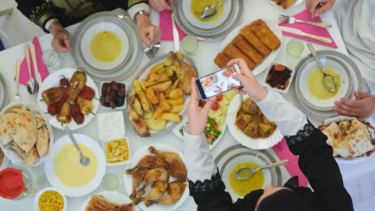 Festliches Zuckerfest Essen wird fotografiert. Ein reich gedeckter Tisch mit Suppe, Hähnchen, gefüllten Paprika und Brot.