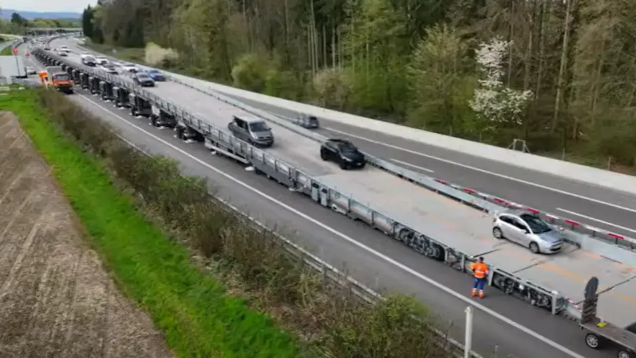 Un puente móvil transporta varios coches por una autopista.