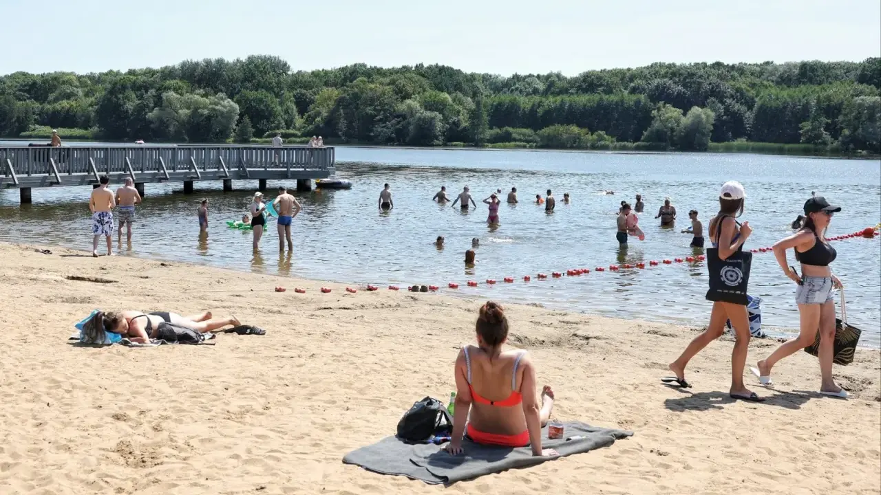 Ludzie kąpią się i opalają nad wodą, ciesząc się jednym z najładniejszych jezior w Wielkopolsce.