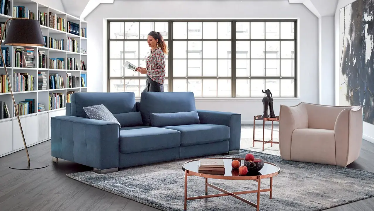 Salon moderne avec canapé bleu, fauteuil beige et bibliothèque. Quelle couleur de canapé choisir pour un style contemporain ?