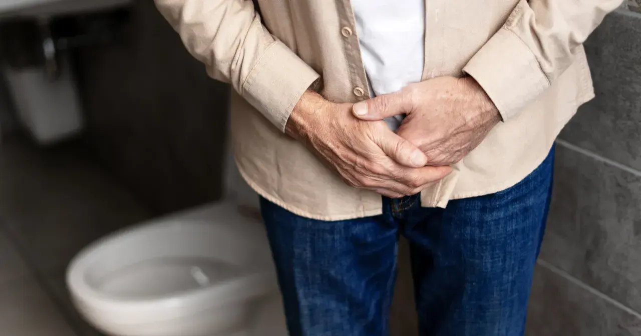 Mężczyzna trzyma się za podbrzusze, zastanawiając się, jakie badania na prostate są najlepsze.