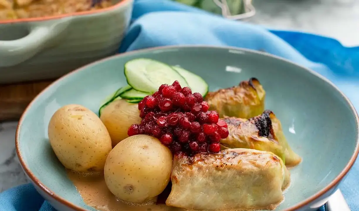Kåldolmar recept: Varma kåldolmar med kokt potatis, lingon och gurka. En klassisk svensk rätt som passar perfekt till middag.