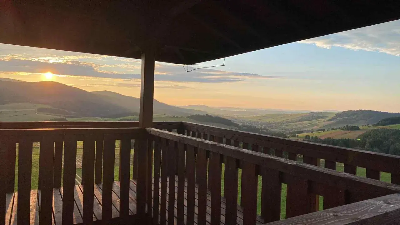 Widok z wieży widokowej na malownicze **beskid niski szczyty** o zachodzie słońca.