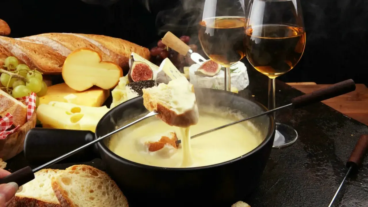 Un délice fumant de fondue au fromage, pain croustillant et vin blanc. Un aperçu des spécialités Auvergne Rhône Alpes.