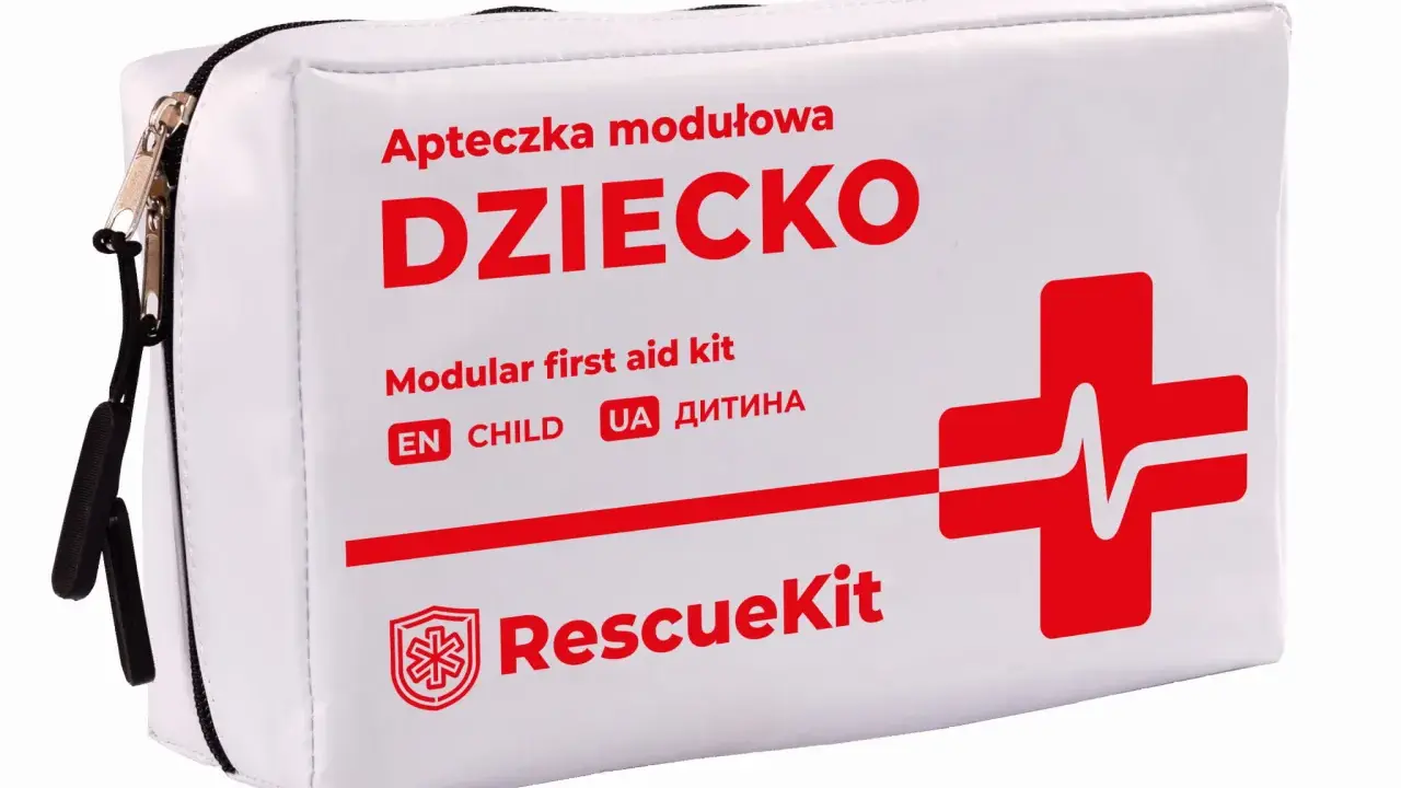 Biała apteczka na wyjazd z dzieckiem, z napisem "DZIECKO" i czerwonym krzyżem ratunkowym. Zapewni bezpieczeństwo podczas każdej podróży.