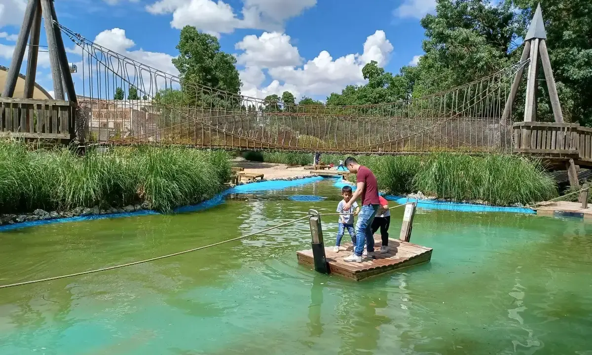 Un padre y sus hijos disfrutan de un día de aventura en un parque acuático en Valladolid con niños, navegando en una balsa.