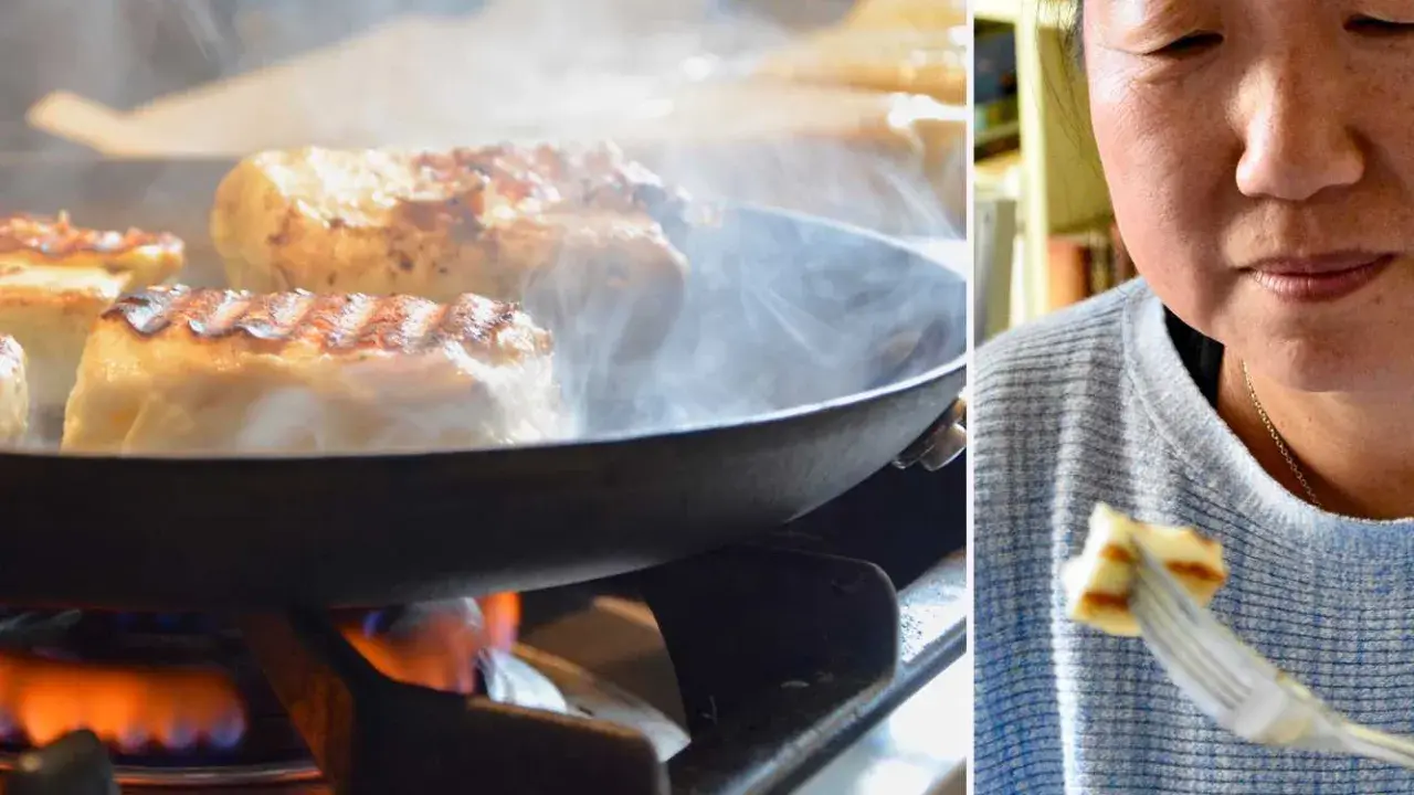 Halloumi steks i panna på spisen, ånga stiger. En kvinna njuter av en bit grillost på en gaffel. Ett enkelt grillost recept.