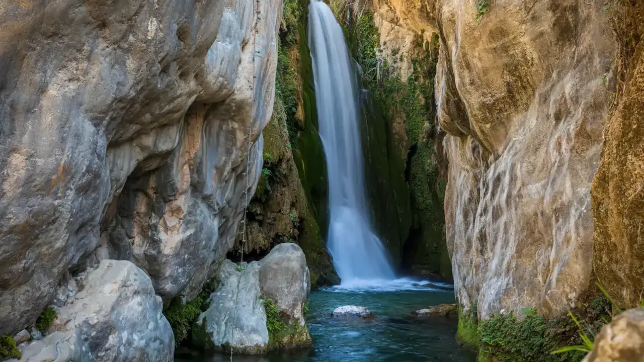 Cascada cayendo en pozas cristalinas, un rincón idílico de piscinas naturales Alicante.