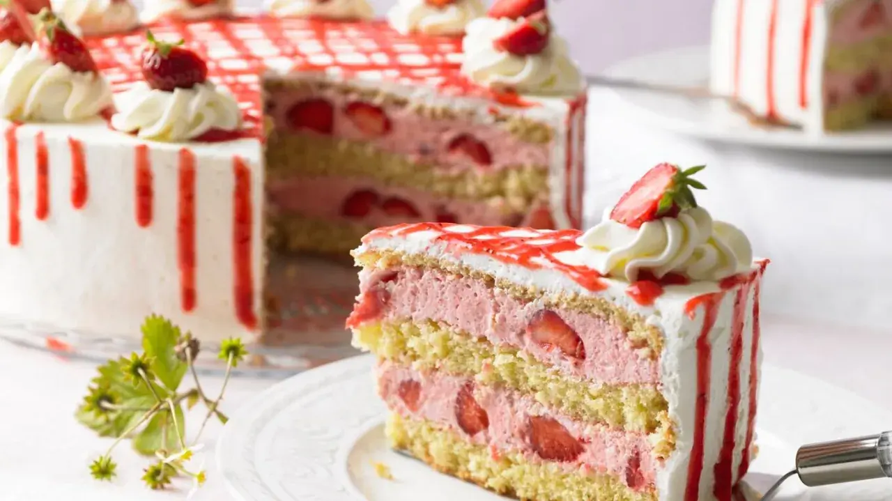 Eine moderne Erdbeertorte mit drei Schichten Biskuit, Erdbeercreme und frischen Erdbeeren, verziert mit Sahnetupfern und rotem Zuckerguss.