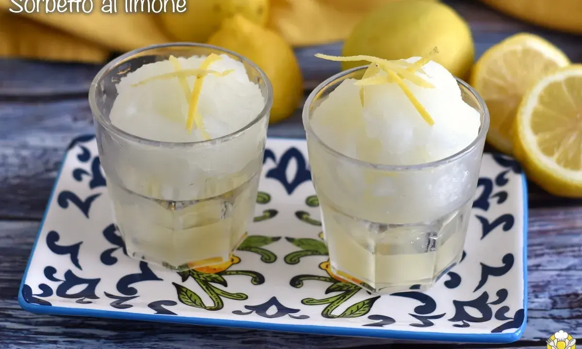 Dos vasos de sorbete de limón, refrescante y con un toque de ralladura de limón, listos para disfrutar.