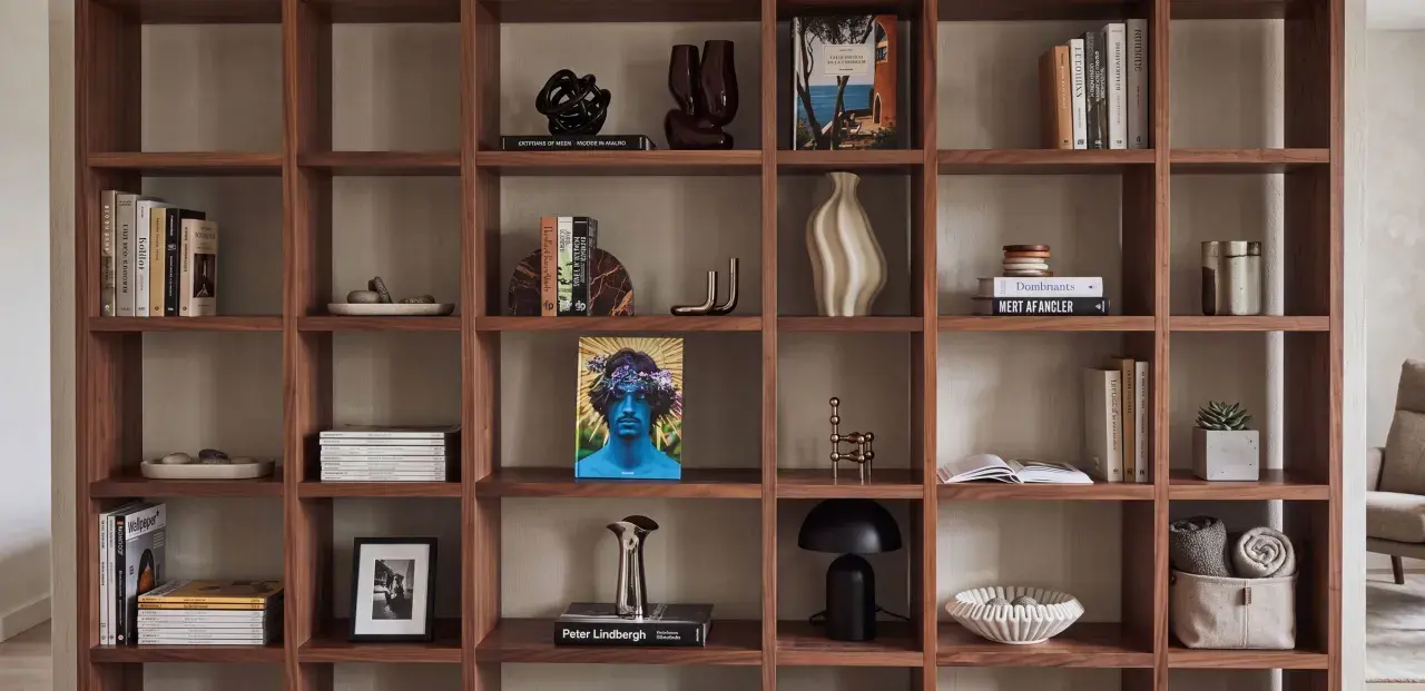 Ideas para decorar una estantería: libros, jarrones, esculturas y plantas crean un espacio acogedor.