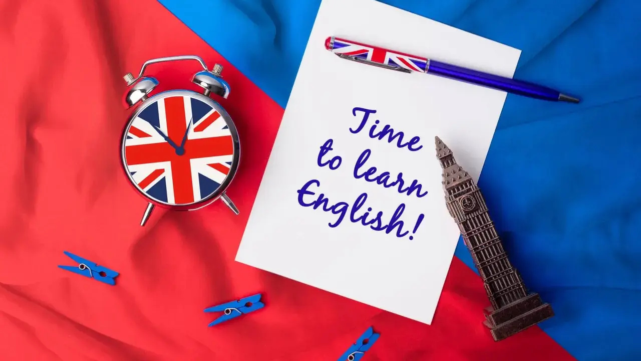 Budzik z flagą UK, długopis i napis "Time to learn English!" na tle brytyjskich barw. Czas na naukę!