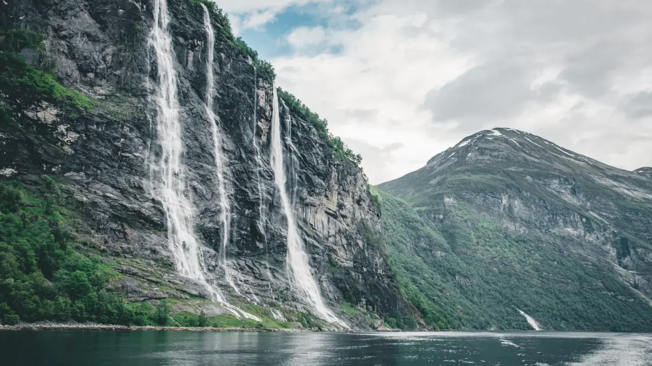 Siedem Sióstr, wodospad w Geirangerfjordzie, to jedno z najpiękniejszych miejsc w Norwegii. Woda spływa kaskadami po skalnej ścianie, tworząc spektakularny widok.