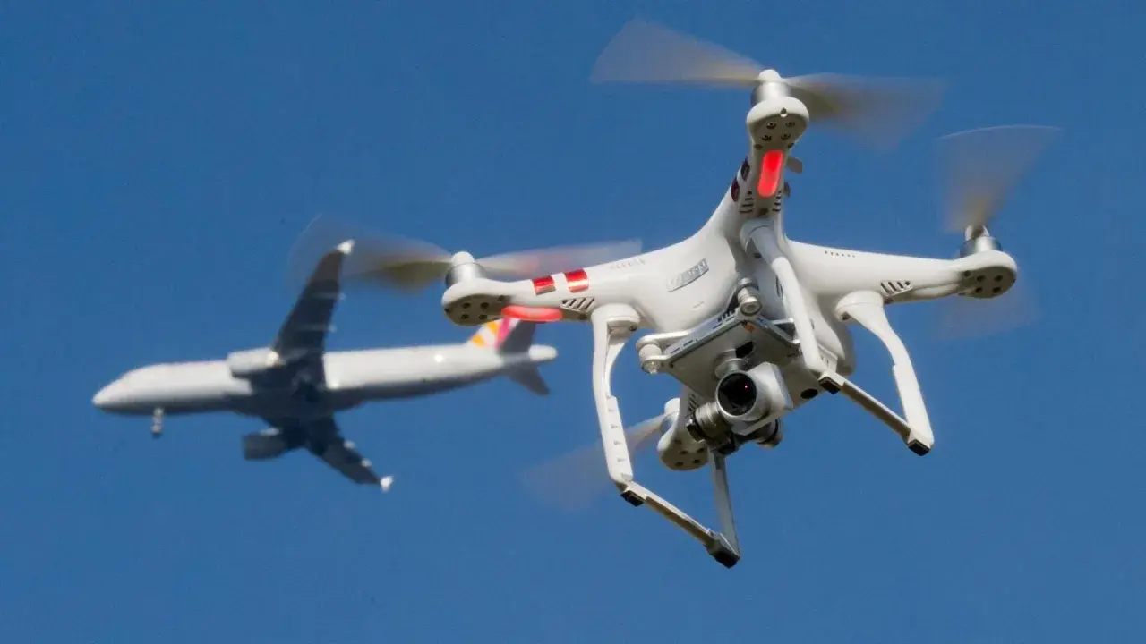 Eine Drohne fliegt in Deutschland nah an einem Flugzeug vorbei.