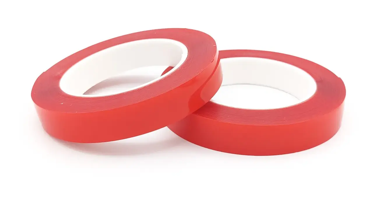 Zwei Rollen rotes Schaumklebeband liegen nebeneinander auf weißem Hintergrund.
