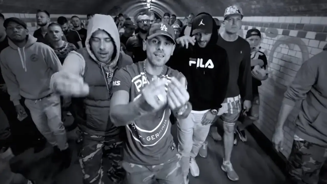 Gibbs, daj tylko czas tekst. Grupa mężczyzn w tunelu, jeden z nich w bluzie Fila, inny w bluzie z kapturem.