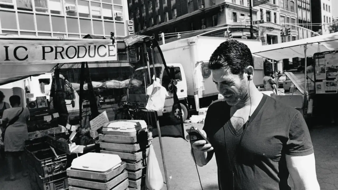 Uomo con auricolari al mercato, un'istantanea di Lee Friedlander.
