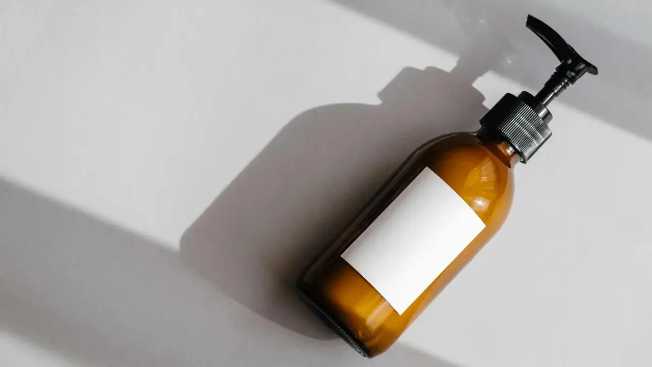 Flacone ambrato con etichetta bianca vuota e dispenser nero. Attenzione agli ingredienti come il cetearyl alcohol fa male.