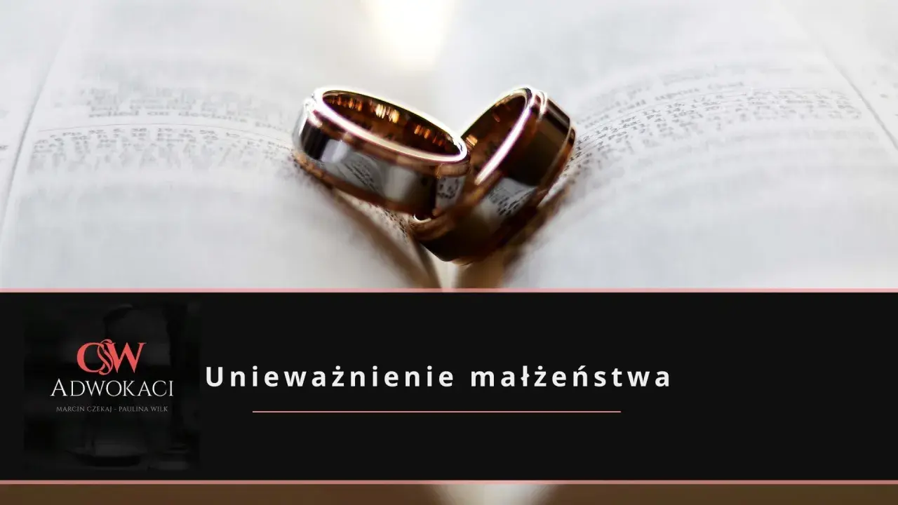 Dwa obrączki na otwartej księdze symbolizują rozważania o **unieważnieniu małżeństwa**.