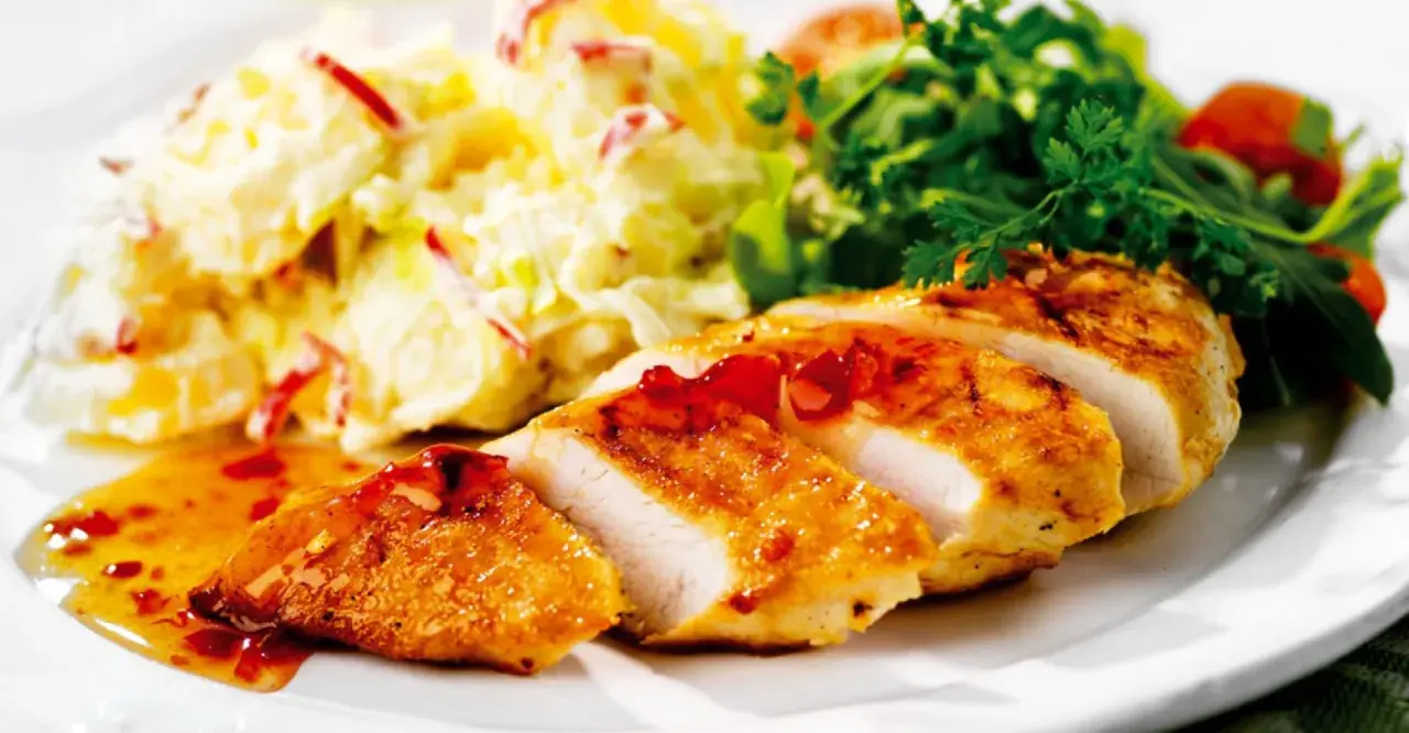 En saftig kycklingfilé serveras med en krämig fransk potatissallad med kyckling och en fräsch grönsallad.