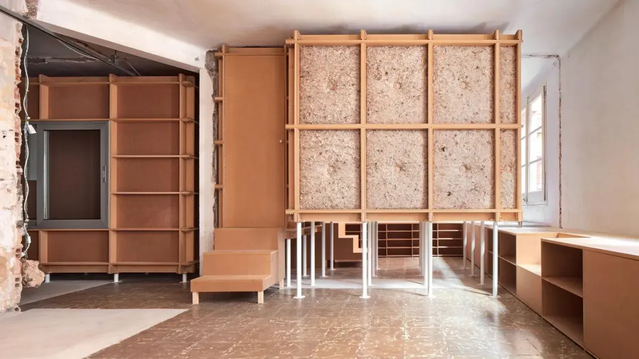 Progetto di ristrutturare casa con 10.000 euro: struttura in legno grezzo, pannelli isolanti e arredi modulari in cartone.