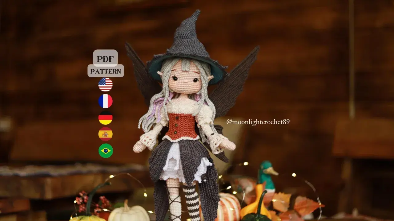 Adorable bruja amigurumi con sombrero puntiagudo y alas. ¡Descarga el patrón gratis en PDF para crear tu propia bruja!