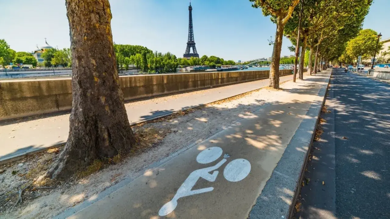 Radweg am Seine-Ufer mit Blick auf den Eiffelturm. Ein Zeichen für die moderne Stadtentwicklung in Paris, die auf nachhaltige Mobilität setzt.