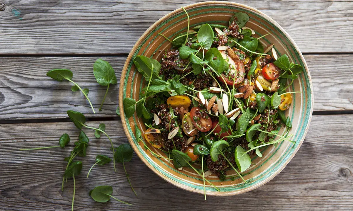 En härlig quinoa sallad med tomater, gröna blad och mandel. Perfekt för ett snabbt och nyttigt quinoa recept.
