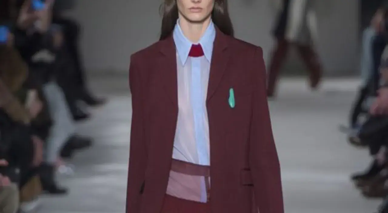 Modella con blazer bordeaux, camicia azzurra e cravatta rossa. Il bordeaux dona un tocco di eleganza sofisticata.
