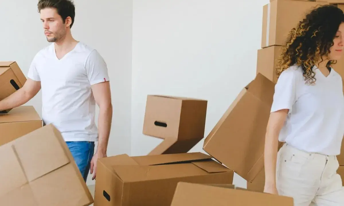 Un couple déménage, entouré de cartons. Le bail est au nom d'un seul, mais ils vivent ensemble.