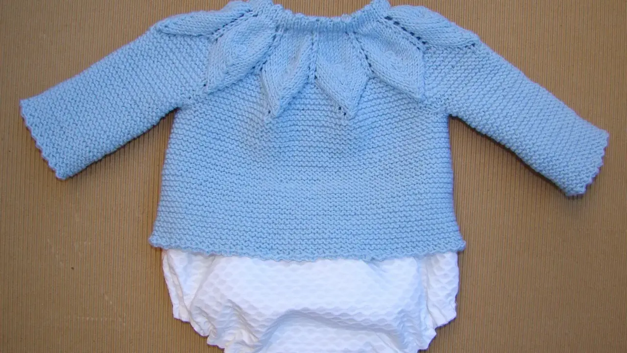 Jersey primera puesta dos agujas paso a paso. Conjunto tejido a mano, jersey azul cielo con cuello de hojas y pololo blanco.