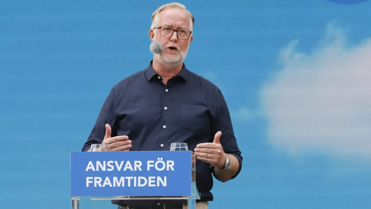 Man med glasögon och mikrofon talar vid ett podium med texten "Ansvar för framtiden". Hans gestik och budskap speglar en liberalism ideologi.