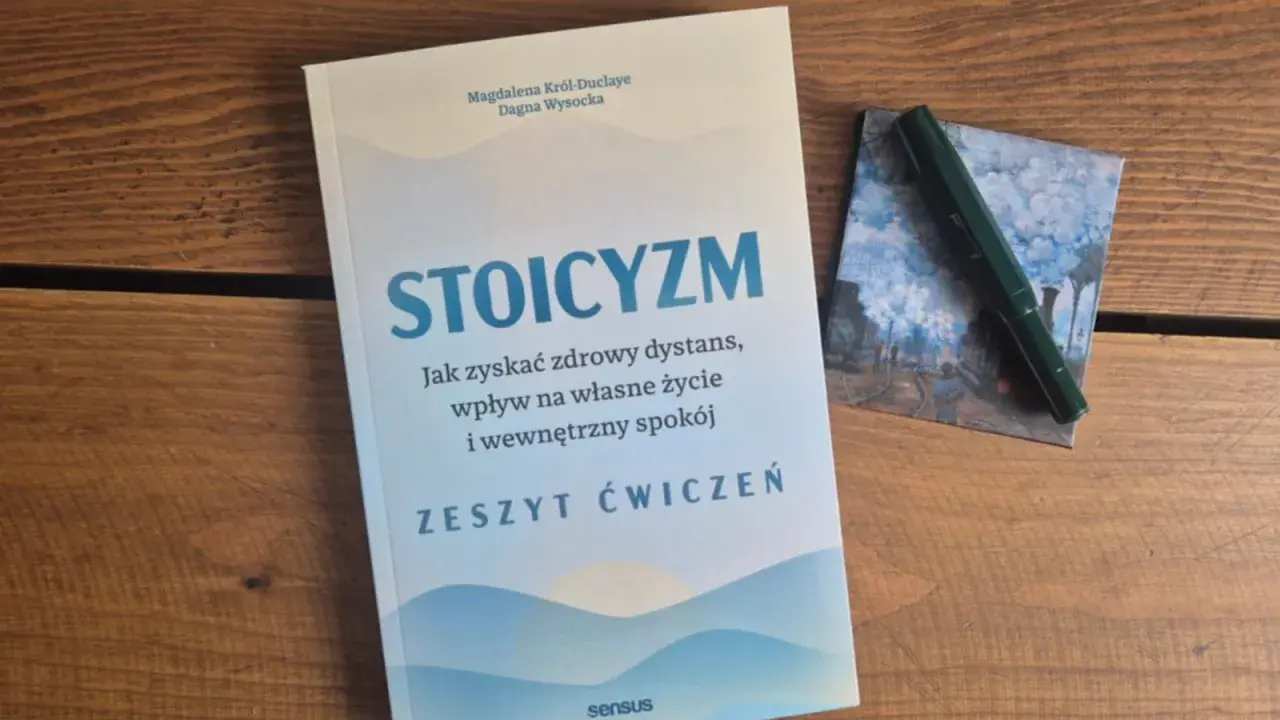 Zeszyt ćwiczeń "Stoicyzm. Jak zyskać zdrowy dystans, wpływ na własne życie i wewnętrzny spokój" obok zielonego pióra. Sztuka życia według stoików.