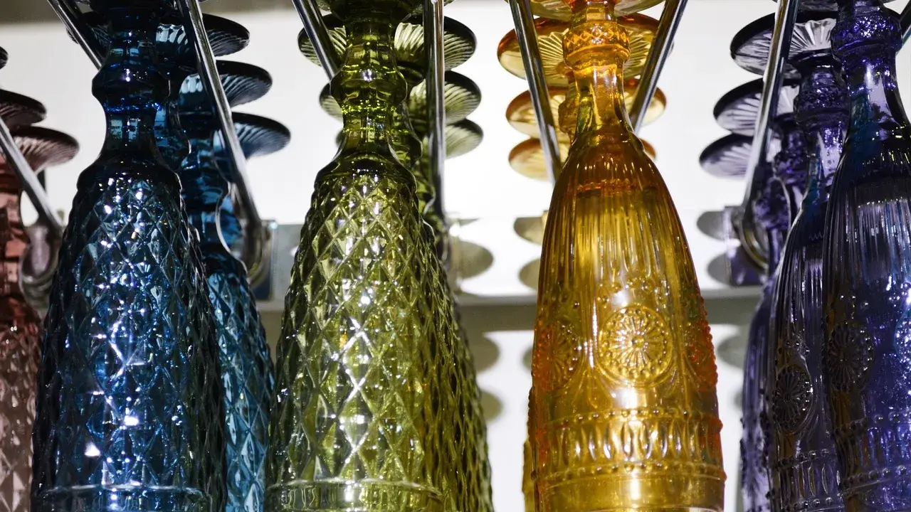 Kolorowe kieliszki i butelki, jak rozpoznać szkło Murano: szukaj unikalnych wzorów i głębokich barw.