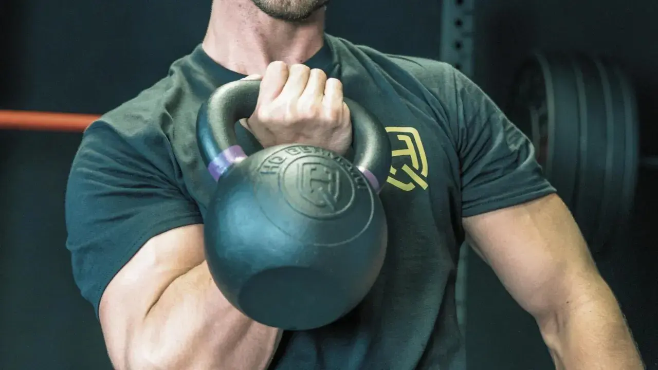 Mann hält Kettlebell, bereit für einen Kettlebell Workout Plan.
