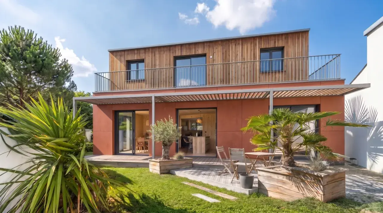 Maison moderne avec bardage bois et façade ocre. Idéal pour un conseil construction maison, avec jardin verdoyant et terrasse accueillante.